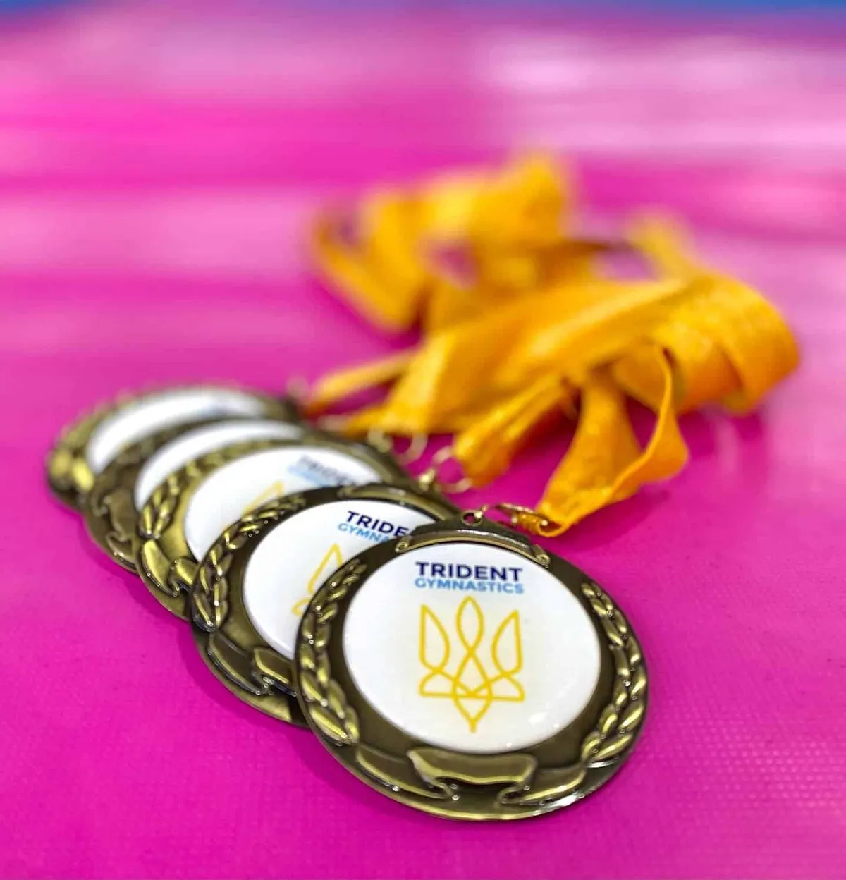 Trident Gymnastics medals with yellow ribbons