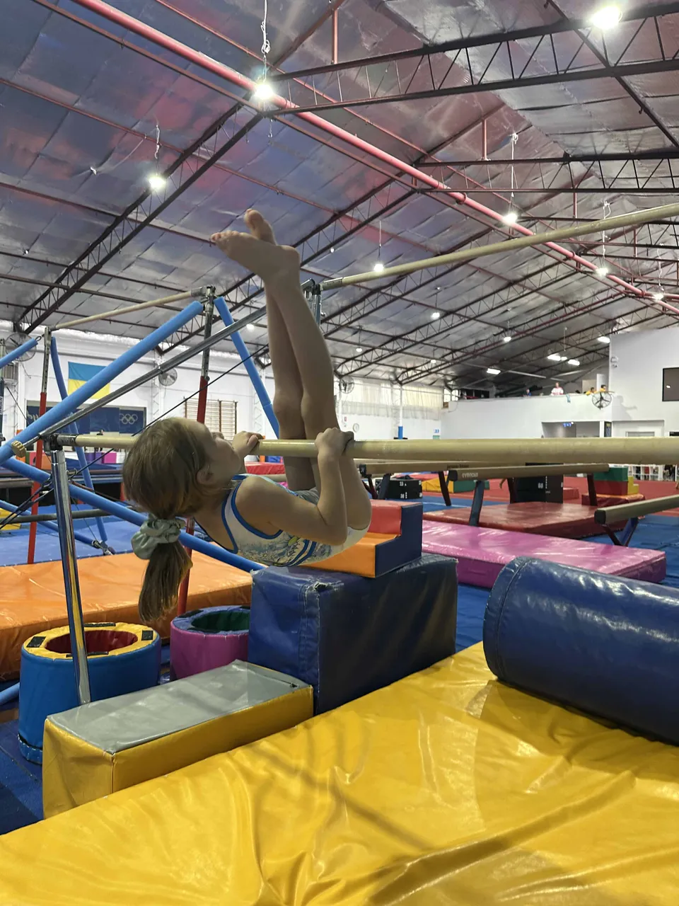 A gymnast performing a pullover on the bars