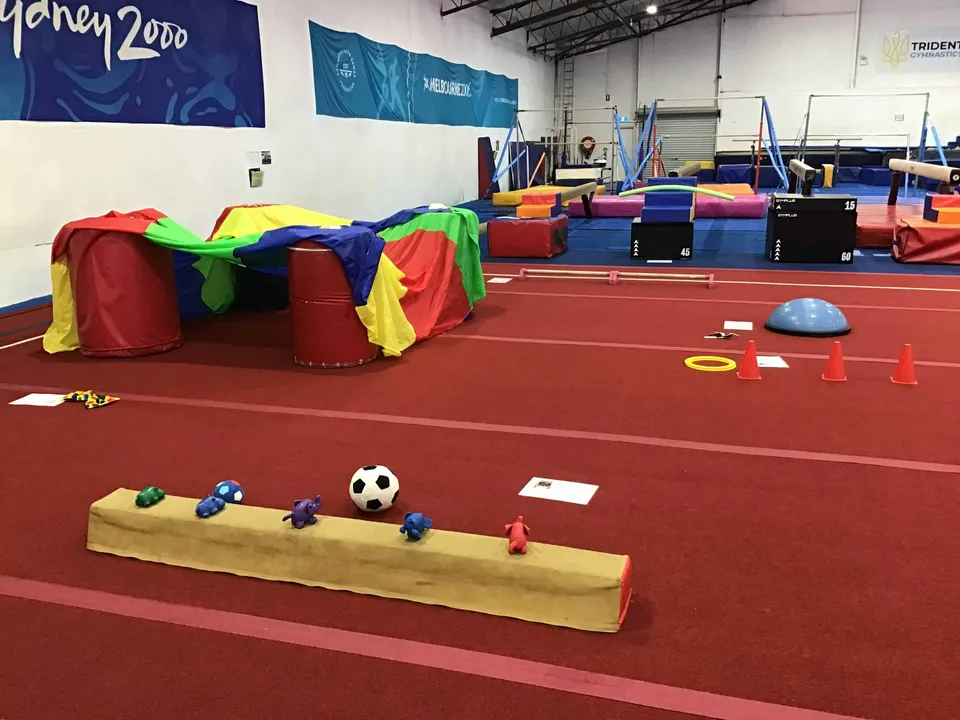 A soft-play course set up with a low balance beam and balls